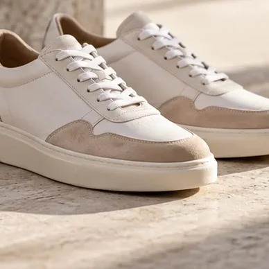Detail van dezelfde crèmekleurige sneakers.