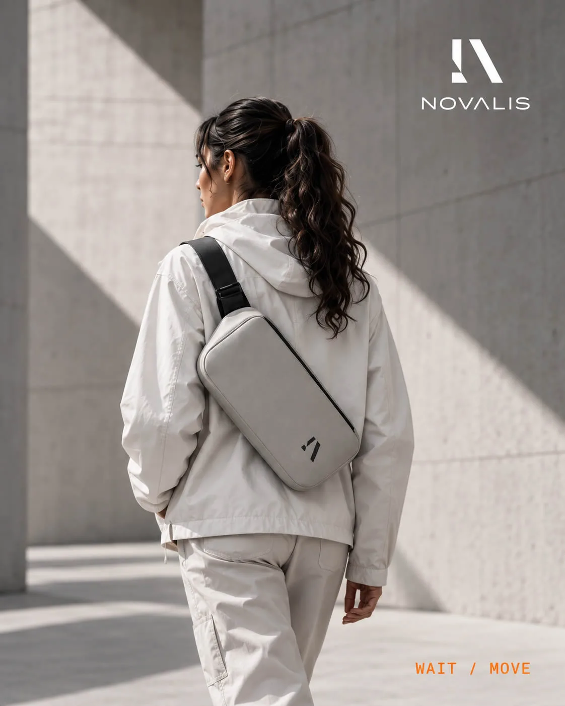 Licht kledingensemble met crossbodytas in een stedelijke omgeving