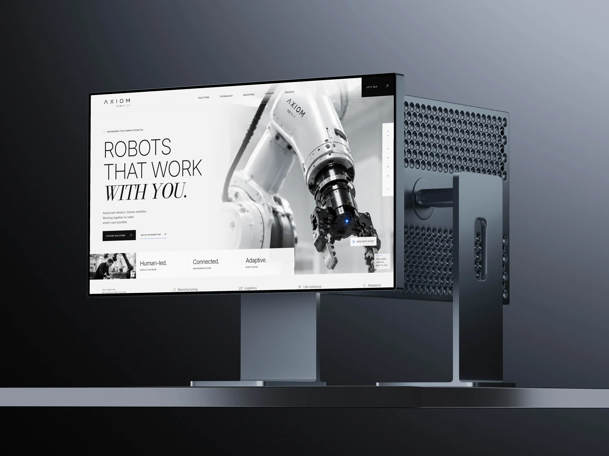 AXIOM-concept op een desktopmonitor: een robotarm naast de Engelstalige kop Robots that work with you.